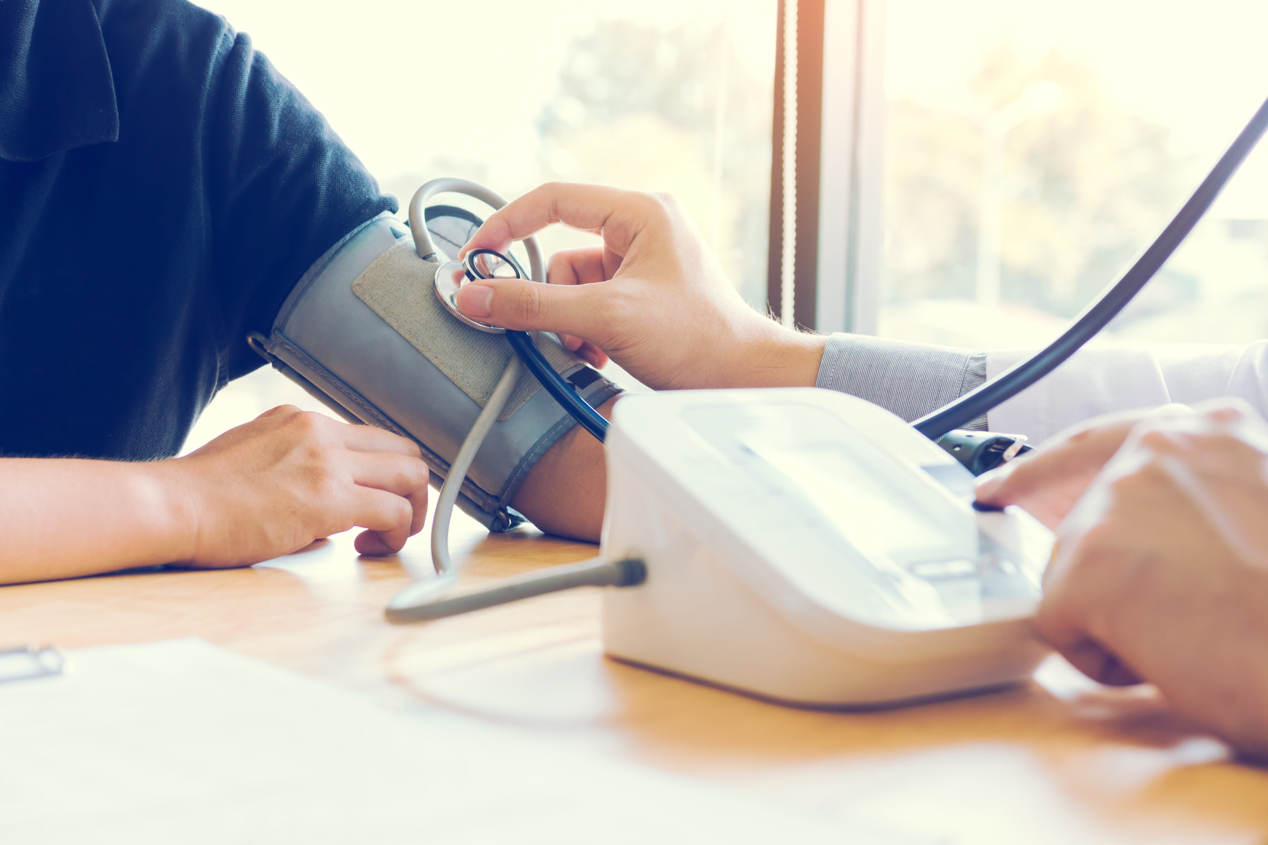 Man checking blood pressure while researching affordable life insurance coverage options
